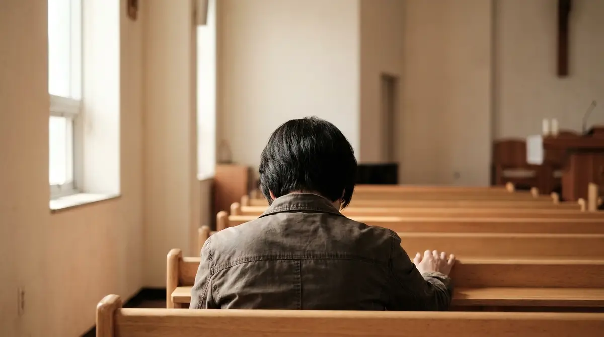 빈 예배당 뒷자리에 한 사람이 뒷모습으로 앉아 손을 긴 의자에 올려놓고 있다